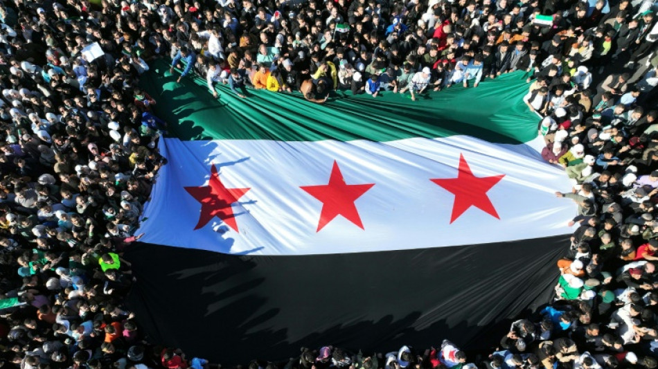 Multid&atilde;o comemora a queda de Assad em Damasco